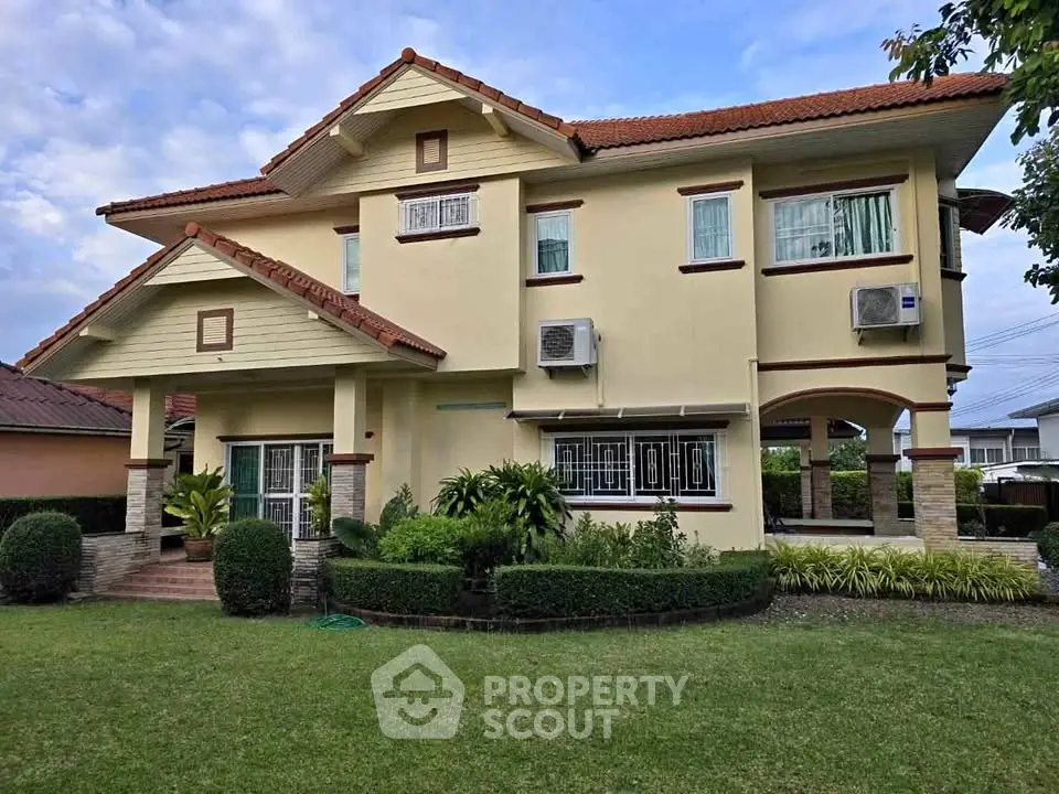 Charming two-story house with manicured lawn and lush greenery, featuring a classic design and modern amenities.