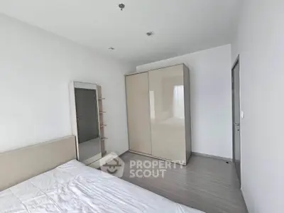 Spacious minimalist bedroom with modern wardrobe and mirror, perfect for a serene living experience.