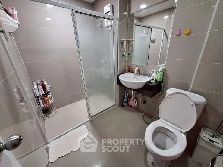Modern bathroom with glass shower and sleek fixtures in stylish home.