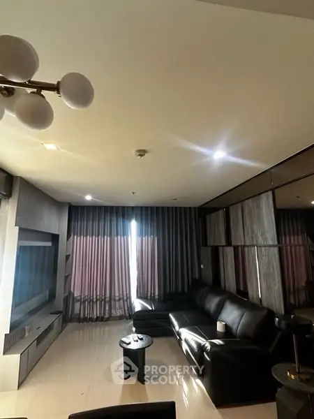 Luxurious modern living room with sleek black leather sofa and elegant lighting