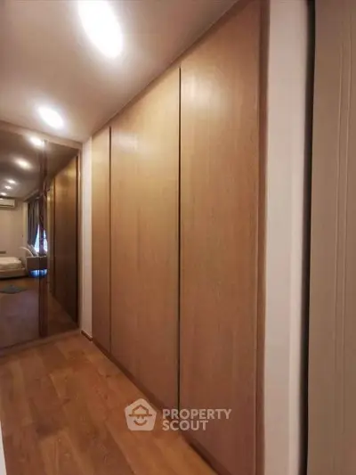 Spacious modern hallway with wooden flooring and sleek built-in storage.