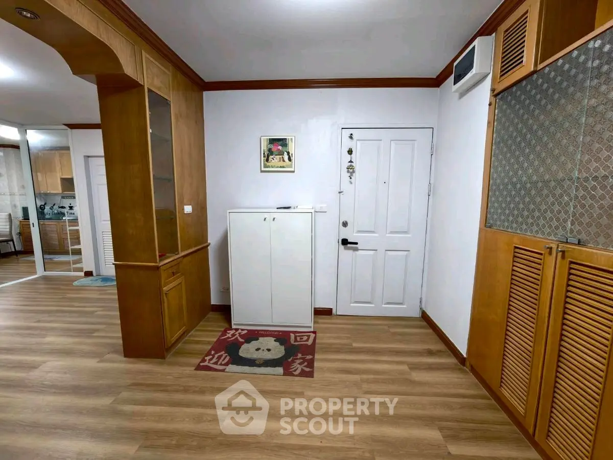 Spacious entryway with wooden accents and decorative rug in modern home