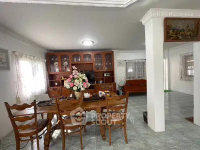 Spacious dining area with wooden furniture and elegant decor in a cozy home setting.