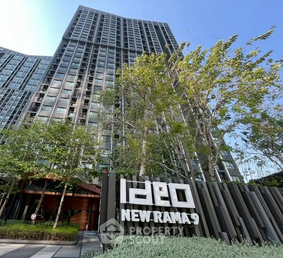 Modern high-rise building with lush greenery at Ideo New Rama 9.