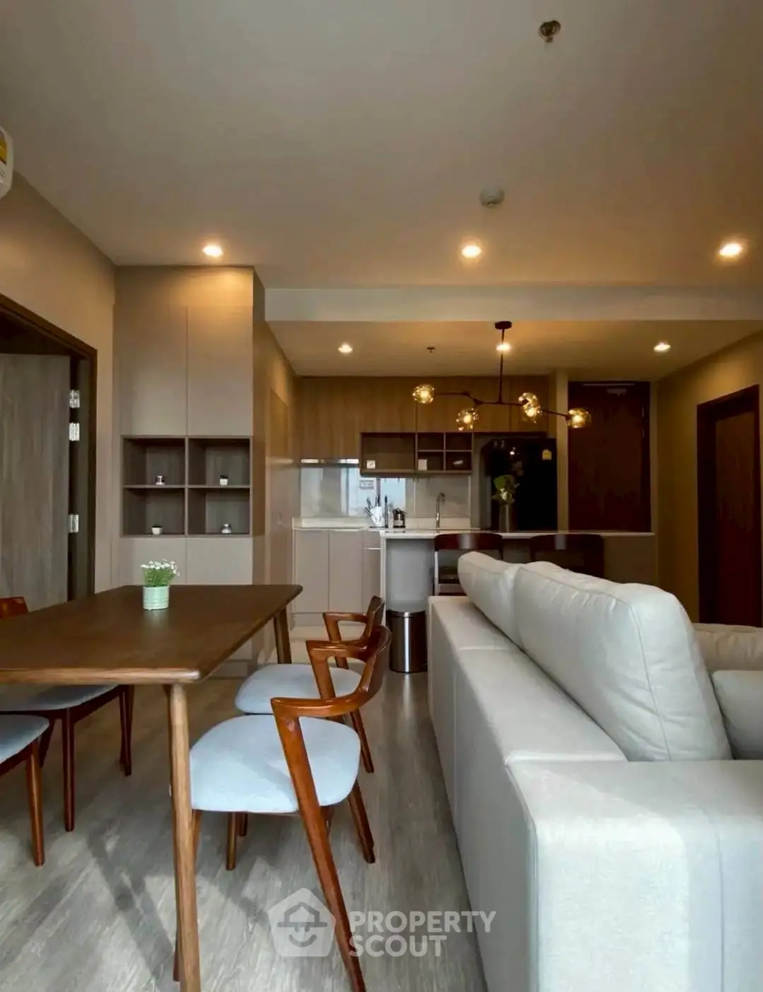 Modern open-layout living room with stylish furniture and kitchen area