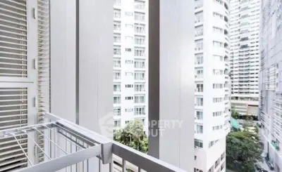 Modern urban balcony with cityscape view of high-rise buildings.