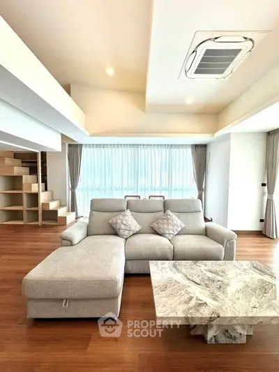 Spacious modern living room with elegant sofa and marble coffee table