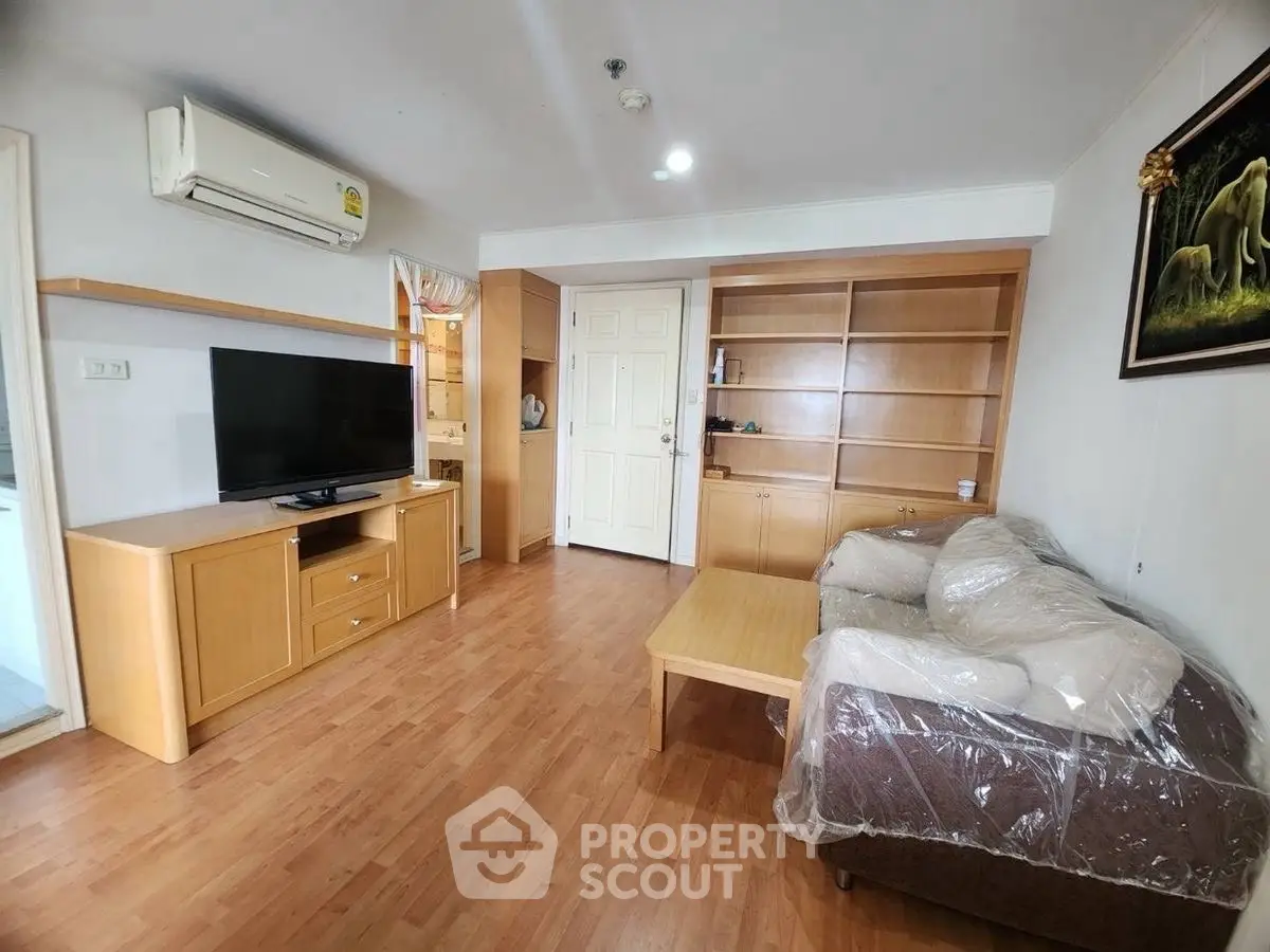 Spacious living room with modern wooden furniture and wall-mounted TV