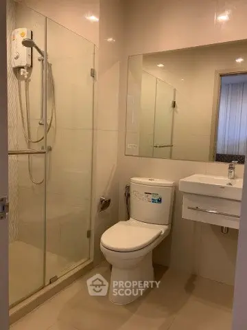 Modern bathroom with glass shower enclosure and sleek fixtures