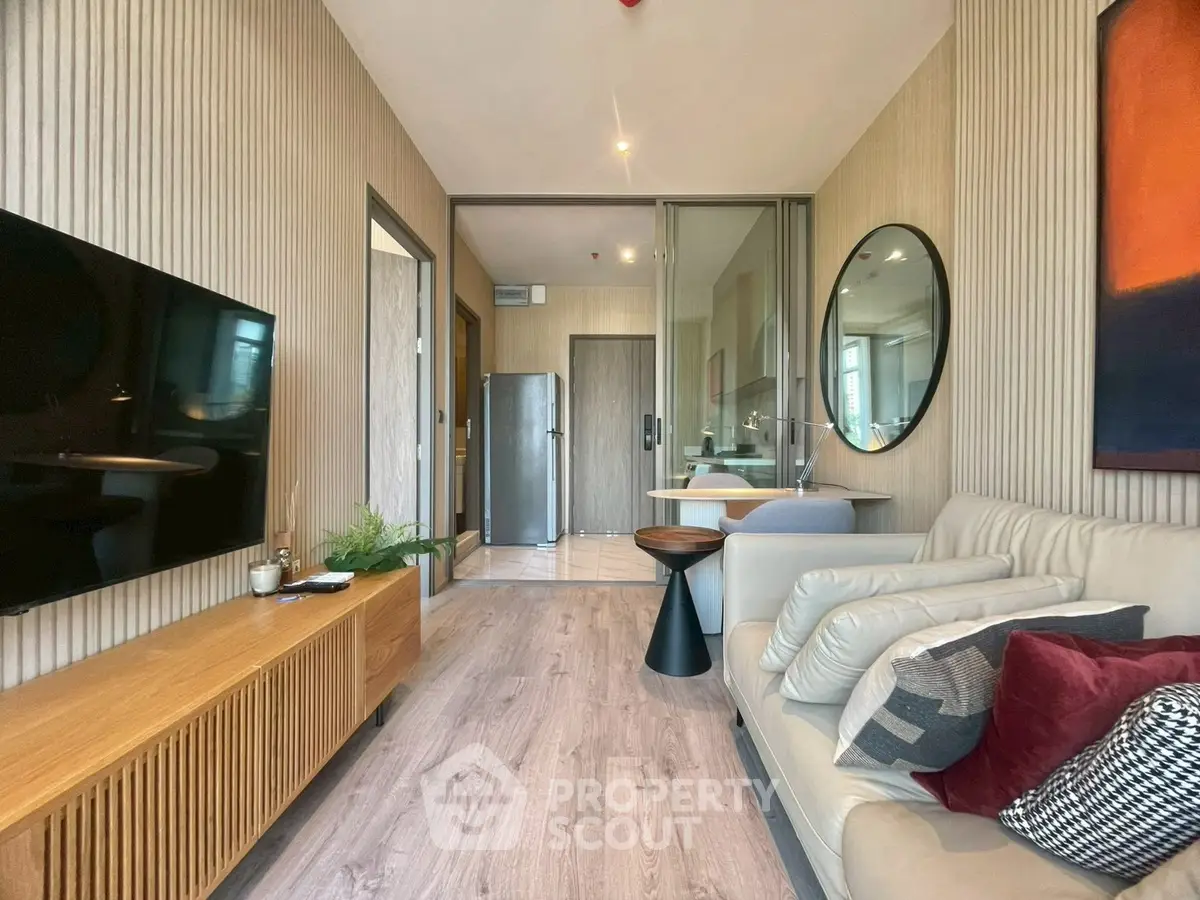 Modern living room with stylish decor and open layout, featuring a cozy sofa and sleek wooden furniture.