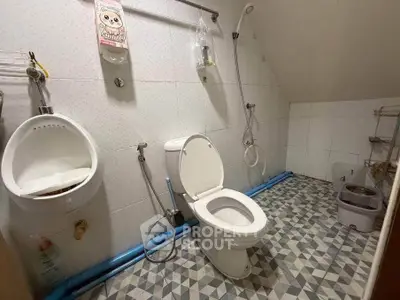 Unique bathroom with geometric floor tiles and modern fixtures in a cozy real estate property.