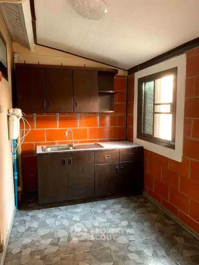Charming kitchen with rustic brick walls and dark wood cabinets, perfect for cozy home cooking.