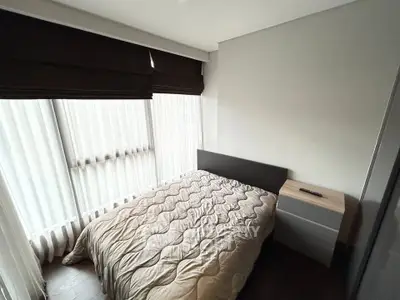 Cozy bedroom with modern decor and large windows for natural light.