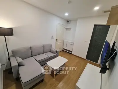 Modern living room with cozy gray sofa and sleek wooden flooring