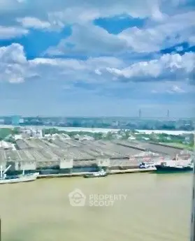 Stunning river view from high-rise building with expansive sky and clouds.