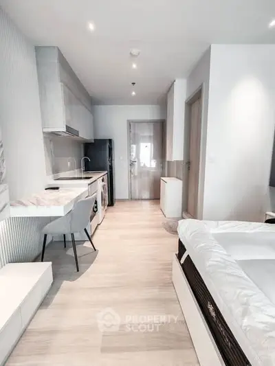 Modern studio apartment with sleek kitchen and cozy living area, perfect for urban living.