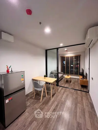 Modern apartment with open layout, featuring a cozy living room and dining area, perfect for urban living.