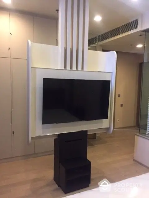 Modern living room with a sleek, wall-mounted fireplace and integrated entertainment system, complemented by elegant cabinetry.