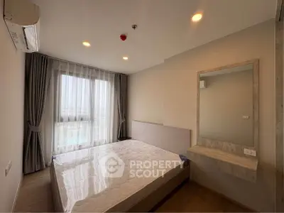 Modern bedroom with large window and stylish decor in a contemporary apartment.