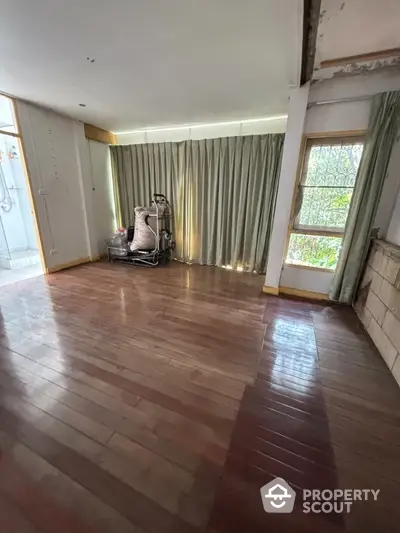 Spacious room with wooden flooring and exercise equipment, ideal for home gym setup.