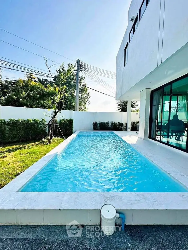 Luxurious modern home with private outdoor pool and lush garden, perfect for relaxation and entertainment.