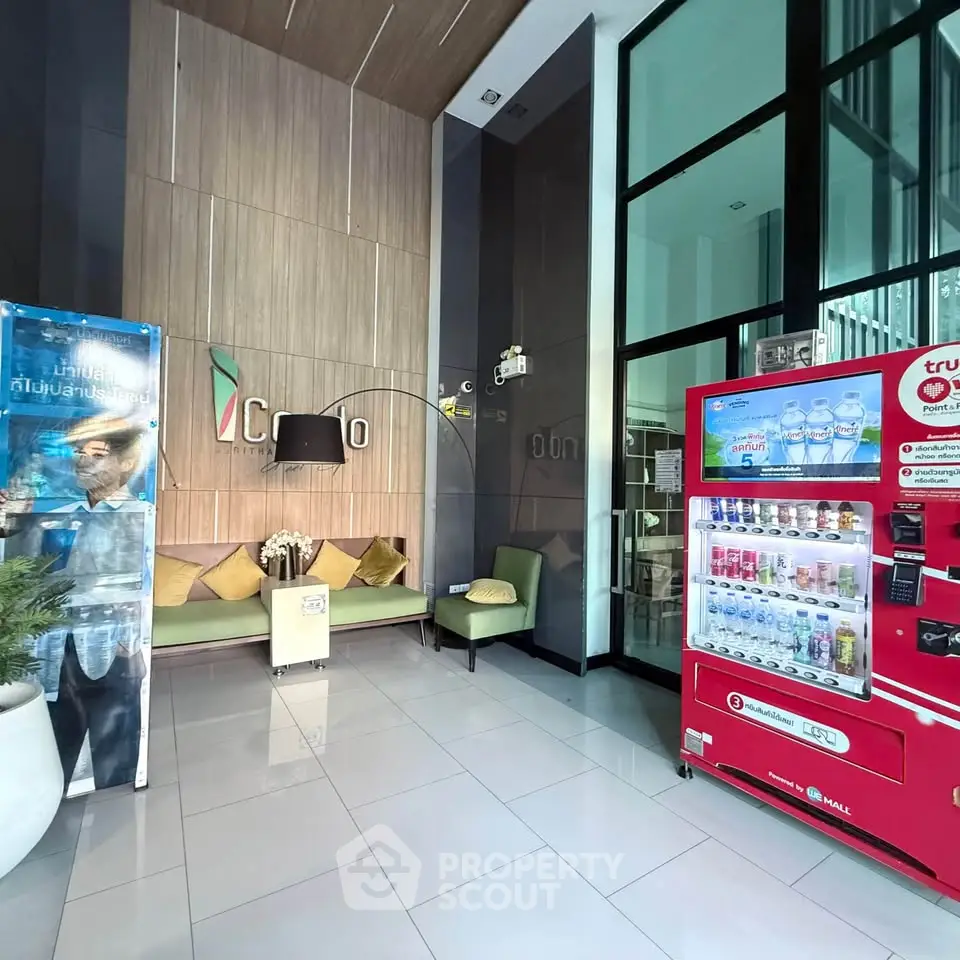 Modern building lobby with vending machine and seating area, showcasing sleek design and welcoming atmosphere.