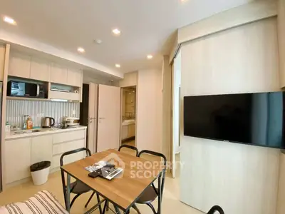 Modern open-layout kitchen and dining area with sleek appliances and cozy seating.
