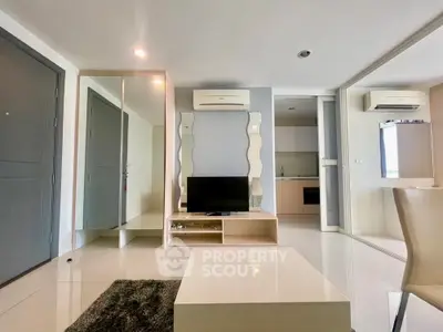 Modern living room with sleek design and open kitchen layout, featuring air conditioning and stylish decor.