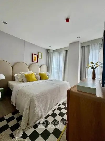 Modern bedroom with stylish decor, featuring a cozy bed, chic furniture, and large windows for natural light.