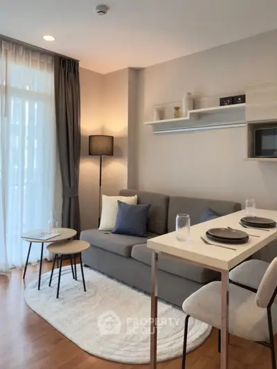 Modern living room with cozy sofa, stylish decor, and natural light in a chic apartment.