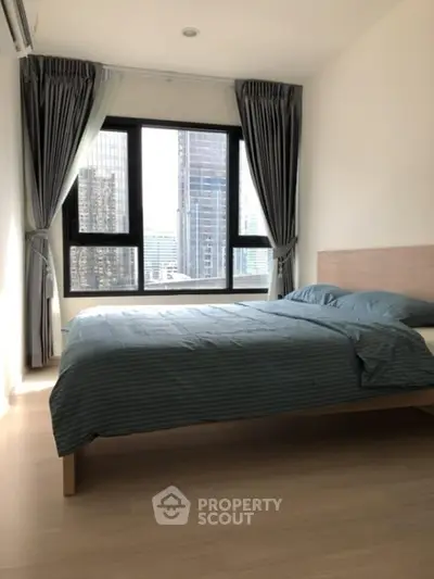 Modern bedroom with city view, large windows, and elegant curtains in high-rise apartment.