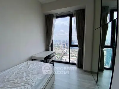 Modern bedroom with stunning city view and large windows in high-rise apartment.