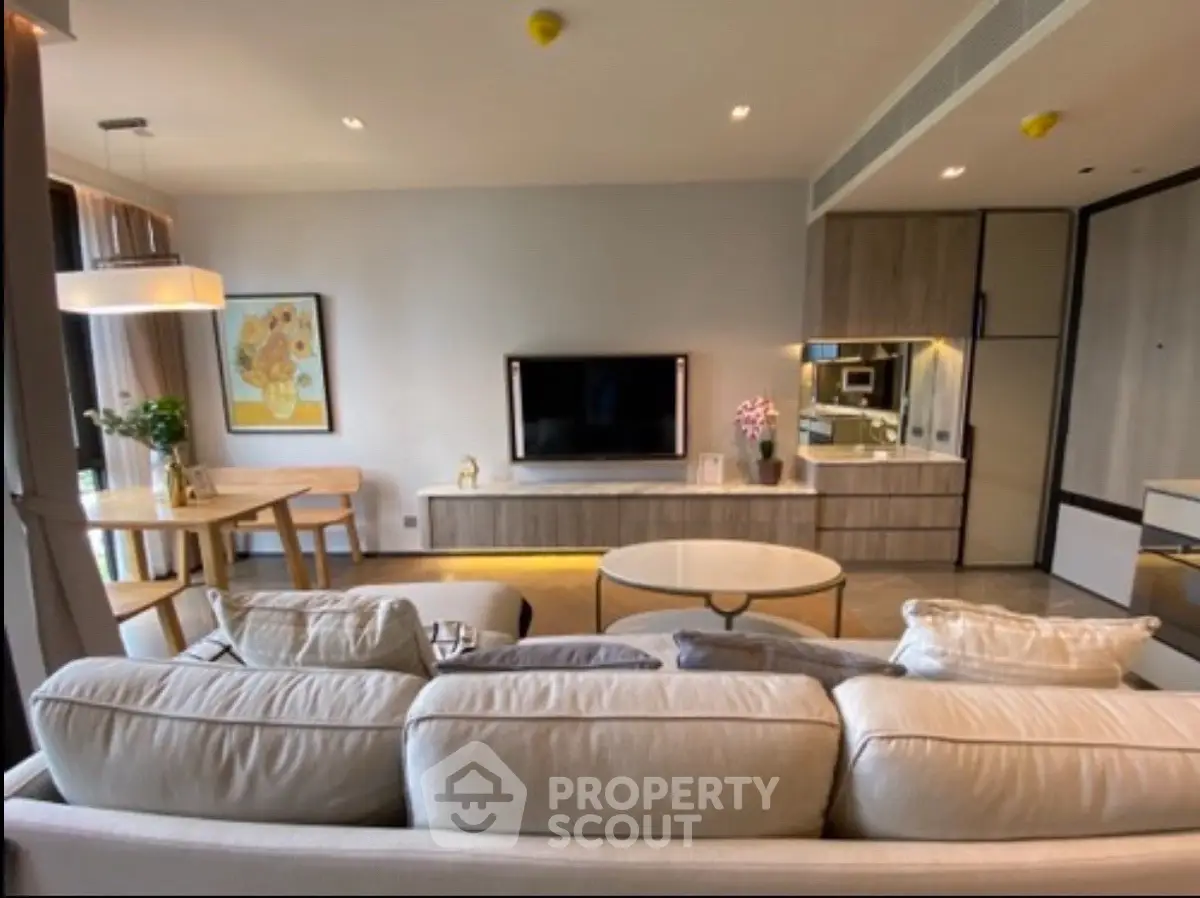 Modern living room with stylish decor and open layout, featuring a cozy sofa and elegant dining area.