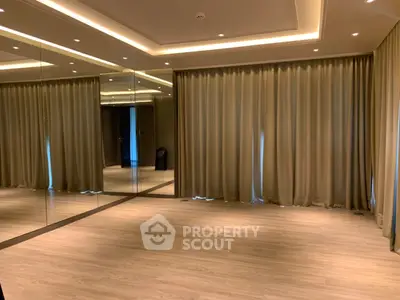Spacious room with mirrored walls and elegant lighting, perfect for modern living.