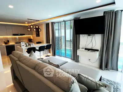 Luxurious open-plan living room with modern kitchen and pool view