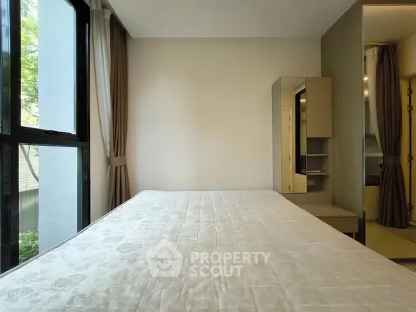 Spacious bedroom with large windows and modern furnishings