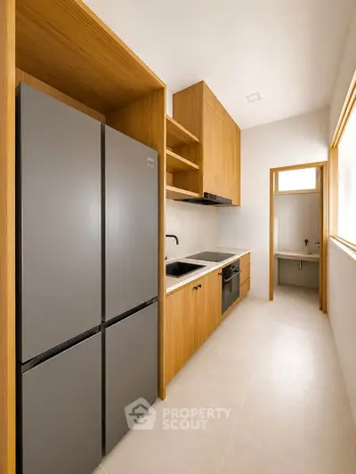 Modern kitchen with sleek appliances and wooden cabinetry in a bright, minimalist design.