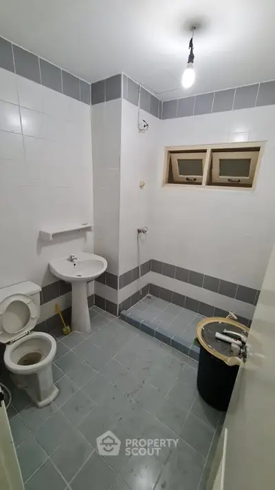 Spacious bathroom with modern fixtures and tiled flooring in a contemporary home.