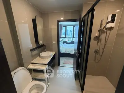 Modern bathroom with sleek design and city view from adjacent bedroom.