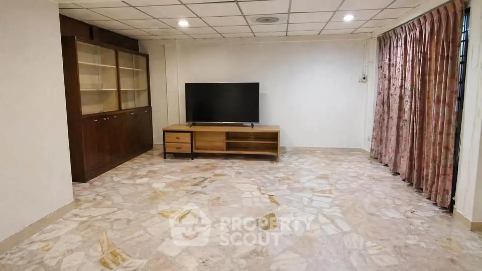 Spacious living room with marble flooring and modern TV setup