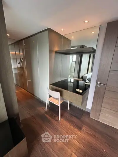 Modern bedroom with sleek wooden flooring and built-in wardrobe
