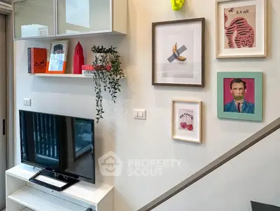 Stylish living room with modern decor and wall art, featuring a sleek TV setup.