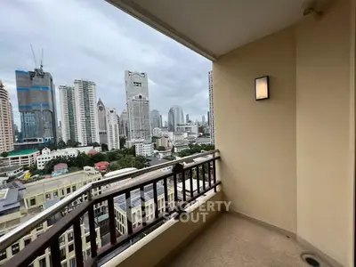 Spacious balcony with stunning city skyline view in modern high-rise apartment.