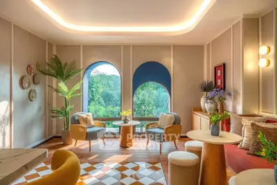 Luxurious living room with elegant decor and stunning garden view through arched windows.