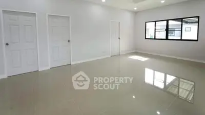 Spacious empty room with glossy tiled floor and large window
