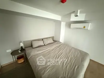 Cozy bedroom with modern air conditioning and minimalist decor, perfect for relaxation.