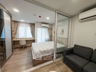 Modern bedroom with glass partition, cozy sofa, and stylish decor