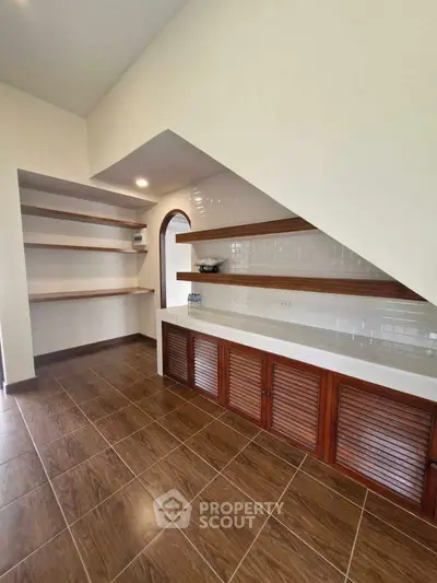 Spacious storage area with wooden shelves and cabinets, ideal for organizing home essentials.