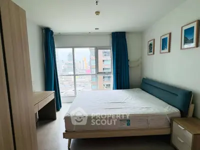 Spacious bedroom with city view, modern furnishings, and natural light in urban apartment.