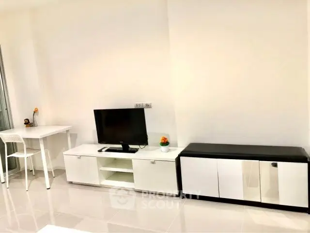 Modern living room with sleek white furniture and a flat-screen TV, perfect for minimalist living.